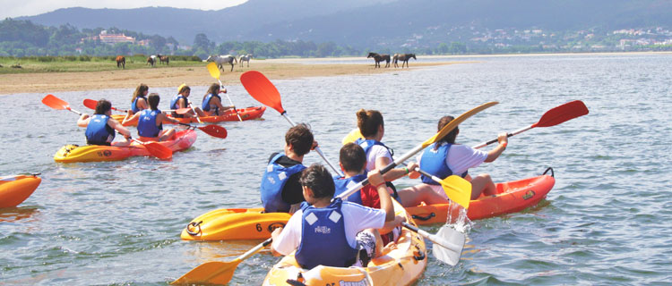 Niños en Kayak con caballos al fondo