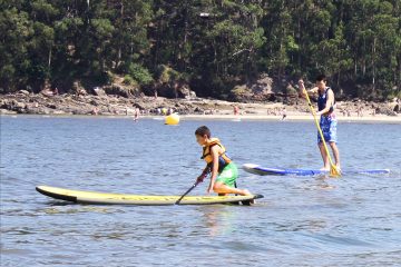 Niños practicando Paddle Surf en la playa