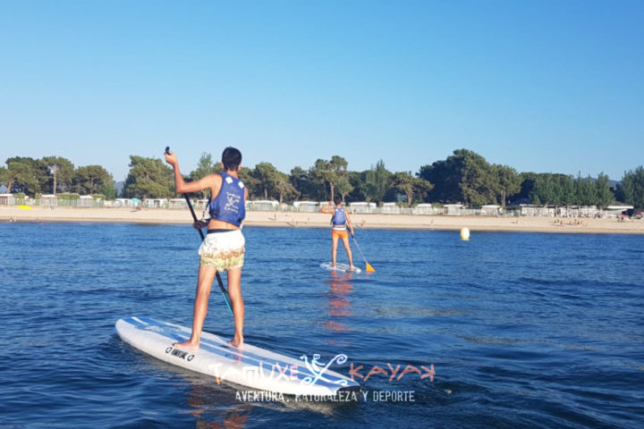 Niños practicando paddle surf en la playa de Ladeira