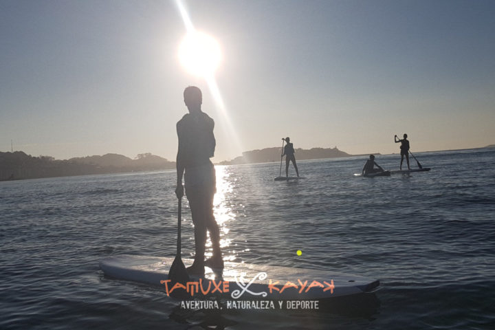 Grupo de amigos disfrutando del paddle surf en Baiona